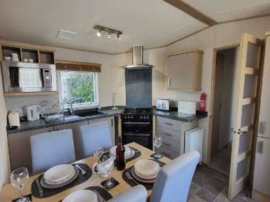 a kitchen with dining table and appliances at Swanage Bay View - Holiday Accommodation 21567, Swanage