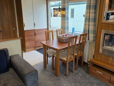 a dining area with a wooden table and chairs at Beacon Fell View Holiday Park - Holiday Accommodation 21653 Preston