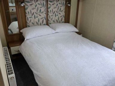 a bedroom with a double bed and decorative headboard at Beacon Fell View Holiday Park - Holiday Accommodation 21653, Preston