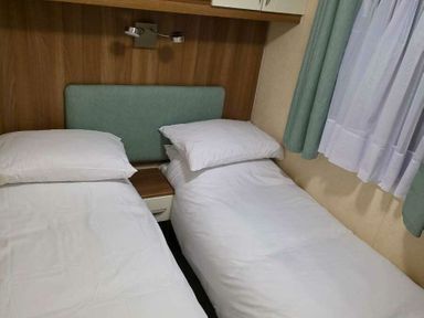 a bedroom with two single beds and a nightstand at Beacon Fell View Holiday Park - Holiday Accommodation 21653, Preston