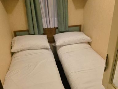 a room with two single beds and green curtains at Beacon Fell View Holiday Park - Holiday Accommodation 21653, Preston