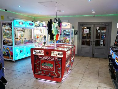 an arcade area with claw machines and a Monopoly game table at Beacon Fell View Holiday Park - Holiday Accommodation 21653, Preston