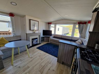 a living room with a television, sofa, and coffee table at Clarach Bay Holiday Village - Holiday Accommodation 21674 in Aberystwyth
