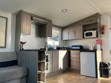 a kitchen with cabinets, sink, stove, and refrigerator at Clarach Bay Holiday Village - Holiday Accommodation 21674 in Aberystwyth