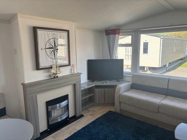 a living room with a TV and a sofa at Clarach Bay Holiday Village - Holiday Accommodation 21674, Aberystwyth