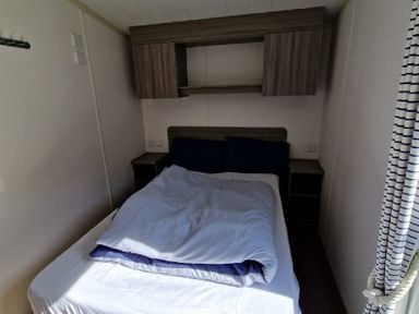 a bedroom with a double bed and cabinets above at Clarach Bay Holiday Village - Holiday Accommodation 21674, Aberystwyth