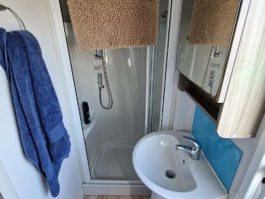 a bathroom with a shower and sink at Clarach Bay Holiday Village - Holiday Accommodation 21674, Aberystwyth