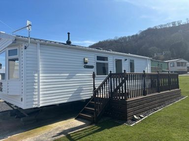 a mobile home with a wooden deck at Clarach Bay Holiday Village - Holiday Accommodation 21674 in Aberystwyth