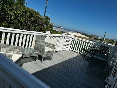 a deck with outdoor furniture and a view at Brynowen Holiday Park - Holiday Accommodation 21677, Borth, Aberystwyth