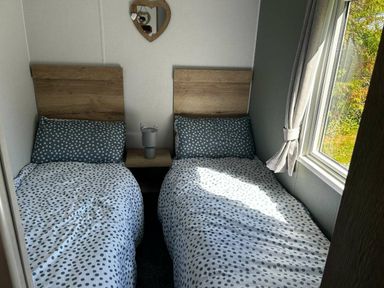 a bedroom with two single beds and a window at Brynowen Holiday Park - Holiday Accommodation 21677, Borth, Aberystwyth