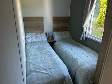 a bedroom with two single beds and a window at Brynowen Holiday Park - Holiday Accommodation 21677 in Borth, Aberystwyth