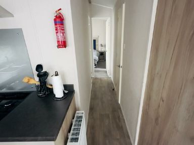 a hallway with a kitchen area on the left at Lido Beach Holiday Park - Holiday Accommodation 21682, Prestatyn