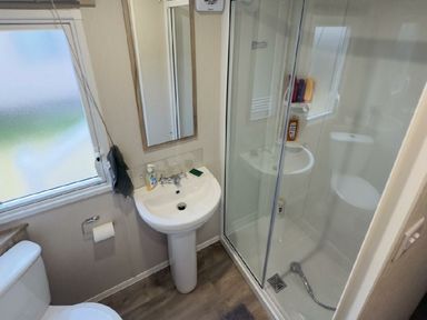a bathroom with a shower, sink, and toilet at Lido Beach Holiday Park - Holiday Accommodation 21682, Prestatyn