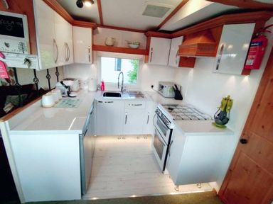 a kitchen with cabinets, countertop, stove, sink, and appliances at Hafan y Mor Haven - Holiday Accommodation 21715 in Pwllheli