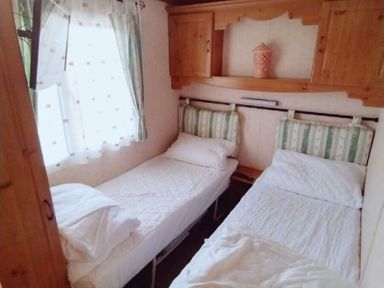a bedroom with two single beds and wooden furniture at Hafan y Mor Haven - Holiday Accommodation 21715 Pwllheli