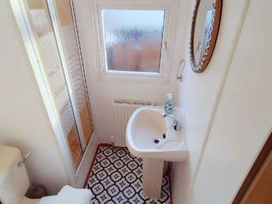 a bathroom with a shower, sink, and window at Hafan y Mor Haven - Holiday Accommodation 21715 Pwllheli