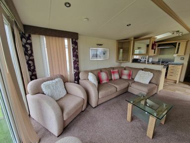 a seating area with a brown sofa and armchairs in Clarach Bay Holiday Village - Holiday Accommodation 21850, Aberystwyth