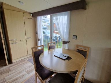 a dining area with a round table and chairs at Clarach Bay Holiday Village - Holiday Accommodation 21850 Aberystwyth