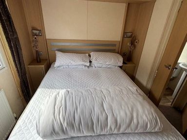a bedroom with a double bed and bedside lamps at Clarach Bay Holiday Village - Holiday Accommodation 21850, Aberystwyth