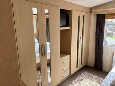 a wardrobe with mirrors and a TV in a bedroom at Clarach Bay Holiday Village - Holiday Accommodation 21850, Aberystwyth
