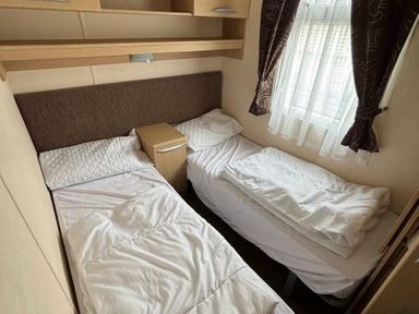 a bedroom with two single beds and a nightstand at Clarach Bay Holiday Village - Holiday Accommodation 21850 Aberystwyth
