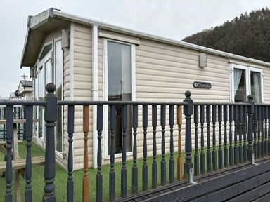 a holiday home with large windows and a deck area at Clarach Bay Holiday Village - Holiday Accommodation 21850, Aberystwyth