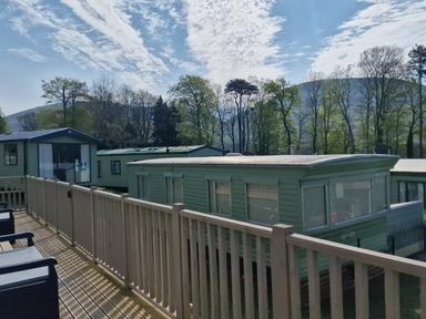 a view of holiday caravans and trees under a cloudy sky at Woodlands Holiday Park - Holiday Accommodation 21859 Twywn
