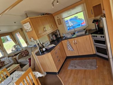 a kitchen with wooden cabinets and a stove at Woodlands Holiday Park - Holiday Accommodation 21859 in Twywn
