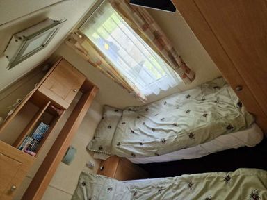 a bedroom with two single beds and a window at Woodlands Holiday Park - Holiday Accommodation 21859 in Twywn