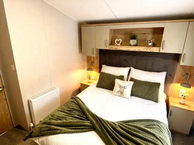 A bedroom with a bed and shelves at Aberdunant Hall Holiday Park - Holiday Accommodation 21962 in Prenteg