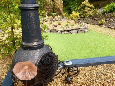 A garden featuring a chiminea and decorative elements at Aberdunant Hall Holiday Park - Holiday Accommodation 21962, Prenteg