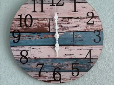 a wall clock with large numbers on a multi-colored wooden background at Valley Farm Holiday Park - Holiday Accommodation 22153 Clacton-on-Sea