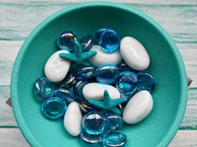 a bowl with blue and white decorative stones and a starfish at Valley Farm Holiday Park - Holiday Accommodation 22153 Clacton-on-Sea
