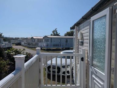 a view from a porch showing caravans and a parked car at Ty Gwyn Caravan Park - Holiday Accommodation 22189 in Abergele