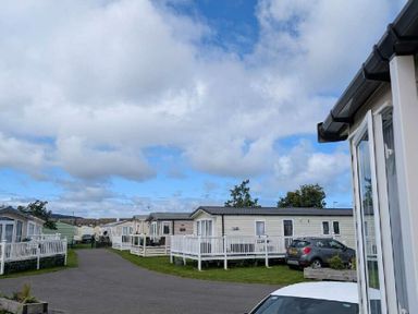 a row of caravans with a cloudy sky at Ty Gwyn Caravan Park - Holiday Accommodation 22189 in Abergele