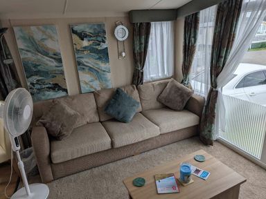a living room with a sofa, wall art, and coffee table at Ty Gwyn Caravan Park - Holiday Accommodation 22189 Abergele