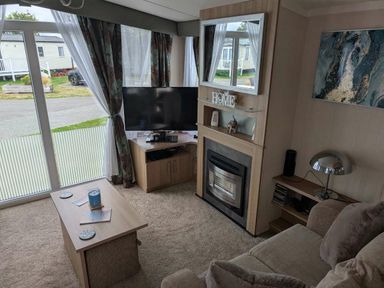 a living room with a television and a fireplace at Ty Gwyn Caravan Park - Holiday Accommodation 22189, Abergele
