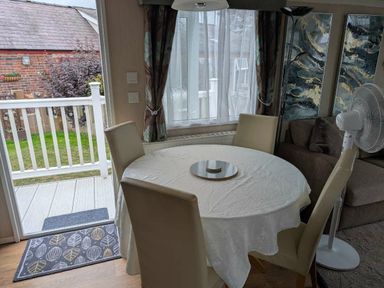 a dining area with a round table and four chairs at Ty Gwyn Caravan Park - Holiday Accommodation 22189 in Abergele