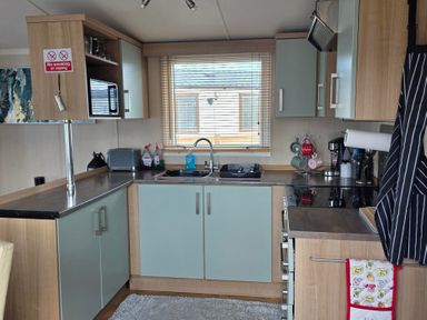A kitchen with cabinets and appliances at Ty Gwyn Caravan Park - Holiday Accommodation 22189 Abergele