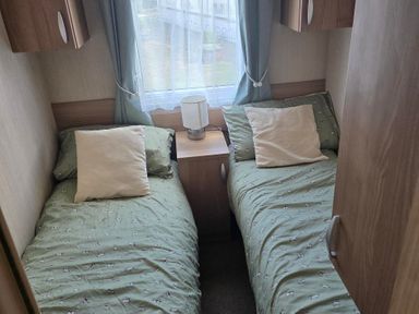 A bedroom with two single beds and a lamp at Ty Gwyn Caravan Park - Holiday Accommodation 22189 Abergele