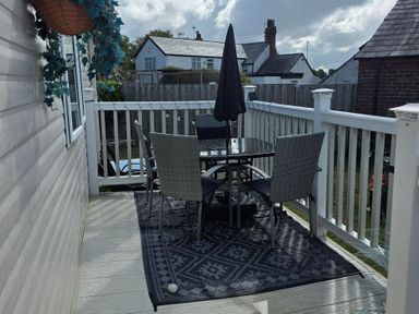 An outdoor patio with a table and chairs at Ty Gwyn Caravan Park - Holiday Accommodation 22189 Abergele