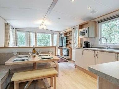 a kitchen and dining area with a table set for two at Kelling Heath Holiday Park - Holiday Accommodation 22244 in Holt