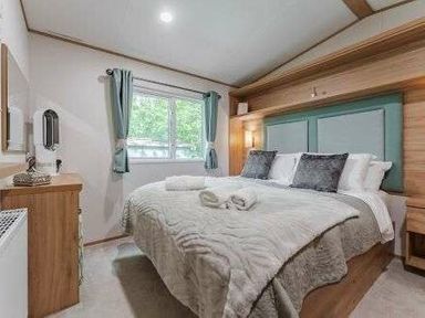 a bedroom with a large bed and a window at Kelling Heath Holiday Park - Holiday Accommodation 22244 in Holt