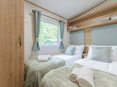 a bedroom with two single beds and a window at Kelling Heath Holiday Park - Holiday Accommodation 22244 in Holt