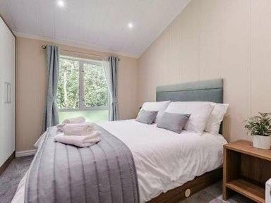 a bedroom with a double bed and window at Kelling Heath Holiday Park - Holiday Accommodation 22249 in Holt