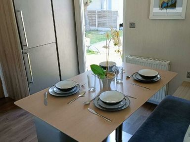a dining table set with plates and glasses at Lyons Winkups and Primrose - Holiday Accommodation 22330 in Towyn
