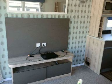 a wall-mounted TV unit with a black device and cables at Lyons Winkups and Primrose - Holiday Accommodation 22330 Towyn