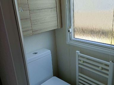 a bathroom with a toilet and a window at Lyons Winkups and Primrose - Holiday Accommodation 22330 Towyn