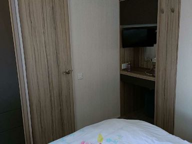 a bedroom with a bed and a small television on a wooden shelf at Lyons Winkups and Primrose - Holiday Accommodation 22330 Towyn