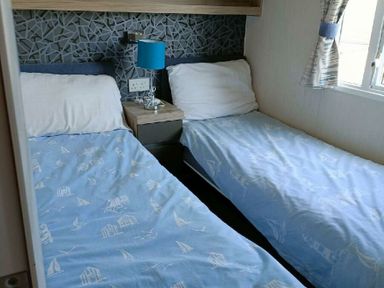 a twin bedroom with two beds and a bedside table at Lyons Winkups and Primrose - Holiday Accommodation 22330 Towyn